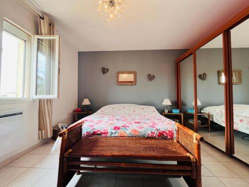 une chambre avec un lit et un grand miroir dans l'établissement Villa climatisée avec jacuzzi, à La Londe-les-Maures