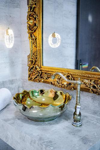 a bathroom sink in front of a mirror and a gold frame at Pousada Dom Pietro in Urubici