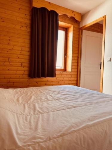 une chambre avec un lit et une fenêtre dans l'établissement Le Tétras Lyre Les Balcons de Recoin, à Chamrousse