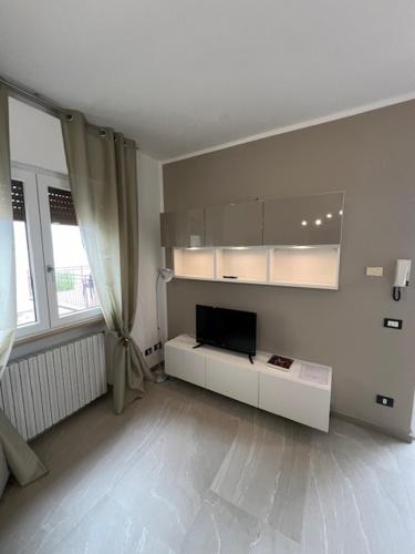 a white living room with a tv and a window at Haus and Beach in Brenzone sul Garda