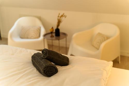 a room with two chairs and a bed with a towel at Chez Julie in Sparsbach