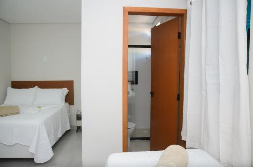 a bedroom with a bed and a door to a bathroom at Aconchego Fabuloso in Penedo