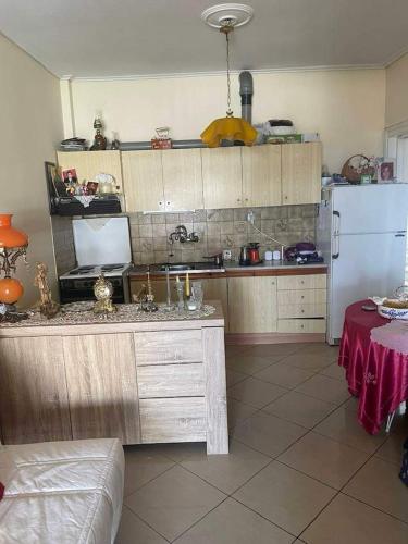 a kitchen with a counter and a refrigerator and a table at Παραθαλάσσια κατοικία παληο καβαλας in Paleo Tsifliki