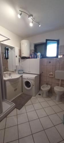 un bagno con un water, un lavandino e una lavatrice di Viola's House a Shkodër