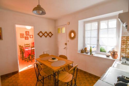 une cuisine avec une table et des chaises dans une pièce dans l'établissement La Maison Bleue, à Lanfains