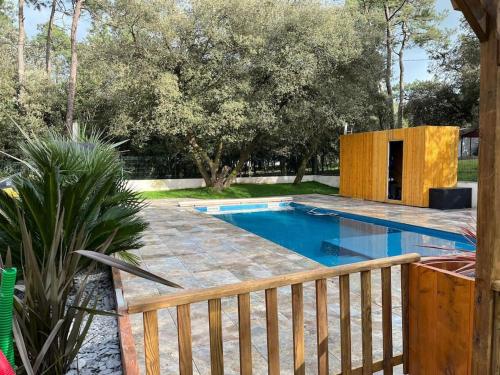 - une piscine dans une cour avec une clôture en bois dans l'établissement Villa 14 personnes Piscine et spa, à Jard-sur-Mer