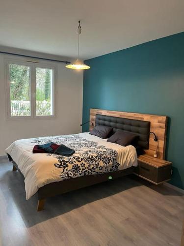 une chambre avec un lit et un mur bleu dans l'établissement Villa 14 personnes Piscine et spa, à Jard-sur-Mer