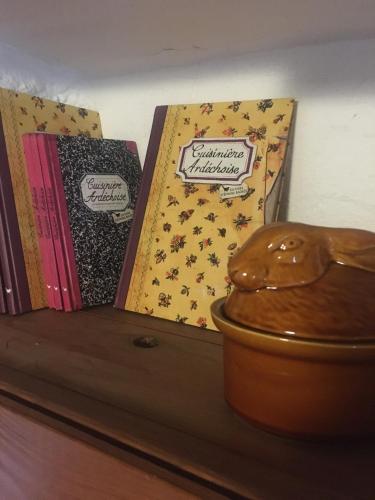 three books sitting on top of a wooden shelf at Gites de Gobertier in Saint-Alban-dʼAy