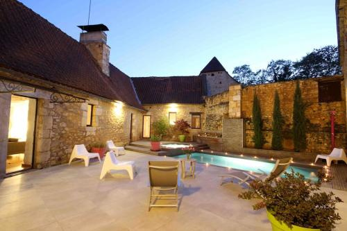 a backyard with a pool and chairs and a building at Le Clos de Peyruzel, Daglan in Daglan