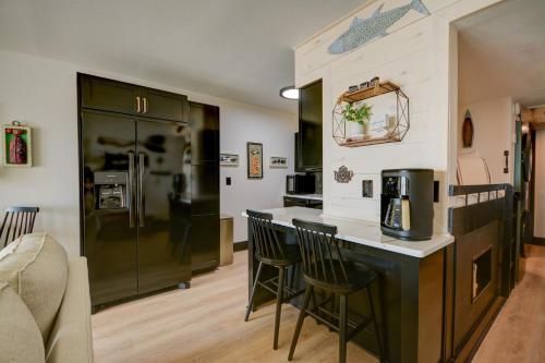 a kitchen with a counter with chairs and a refrigerator at Topsail Dunes 1213 - BLDG 1 in North Topsail Beach