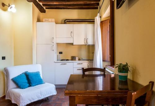 a kitchen with a table and a table and a chair at Massa Alta B&B e Appartamenti in Massa Marittima