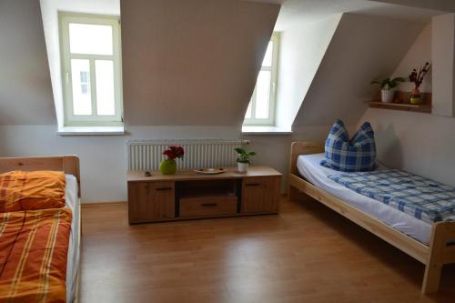 - une chambre avec 2 lits, une table et 2 fenêtres dans l'établissement Im Herzen der Altstadt von Naumburg-Saale, à Naumbourg