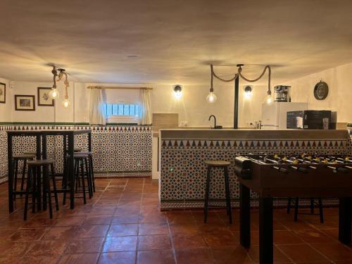 a kitchen with a bar with stools and a counter at Los Ogíjares in Ogíjares