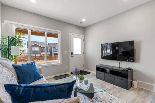 a living room with a couch and a flat screen tv at Brand New Luxury Walk-out Suite - Calgary in Calgary