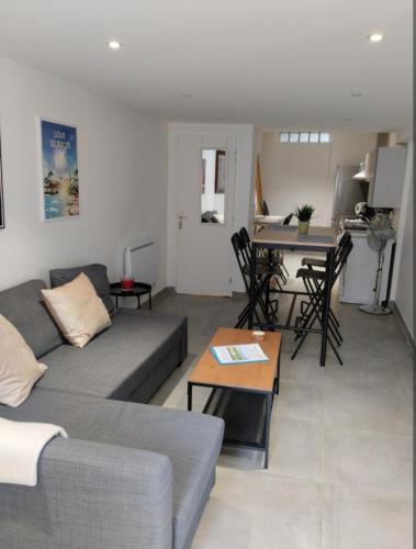 un salon avec un canapé et une table dans l'établissement Maison Cosy Calme Central Bus Lac Kir, à Plombières-lès-Dijon