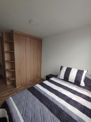 a bedroom with a bed and a wooden cabinet at Apartamento Ibagué in Ibagué
