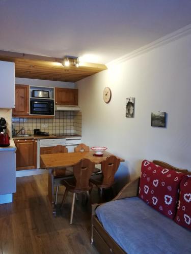 - une cuisine avec une table et un canapé dans une chambre dans l'établissement Hameau de la Vallée d'OR GENTIANES100, à Valloire