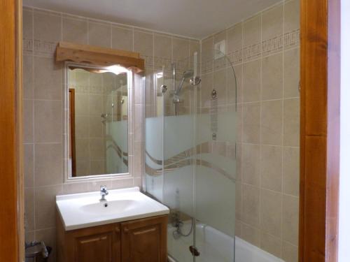 une salle de bain avec un lavabo et une douche avec un miroir dans l'établissement Hameau de la Vallée d'OR GENTIANES100, à Valloire