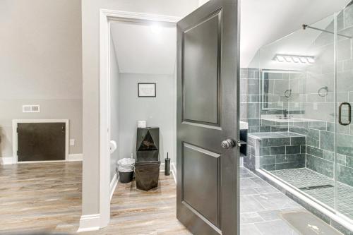Un baño con ducha y puerta de cristal. en Charlotte Home with Yard - Near Spectrum Center!, en Charlotte
