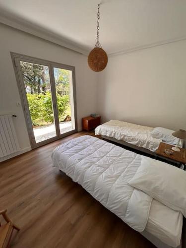 une chambre avec deux lits et une grande fenêtre dans l'établissement Maison à 10 min à pied de la Plage, à Jard-sur-Mer