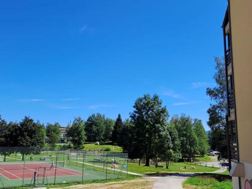 une vue d'un court de tennis avec des gens dessus dans l'établissement l'été en montagne 6 places avec accès piscine, à Ax-les-Thermes