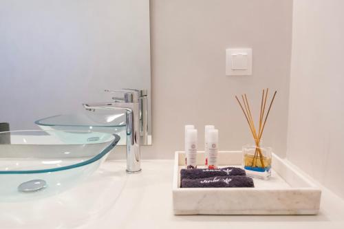 a bathroom with a sink and a glass tub at Alexander Suites in Drios