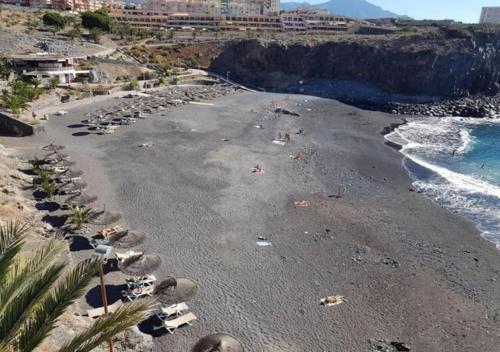 a beach with umbrellas and people on the beach at Central 2Bedroom 200m from beach Callao Salvaje Costa Adeje in Callao Salvaje
