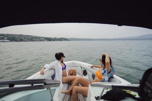 three women sitting in a boat on the water at Hotel Master Club in Tequesquitengo