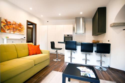ein Wohnzimmer mit einem gelben Sofa und einem Tisch in der Unterkunft Appartamento Melissa in Santa Maria Maggiore