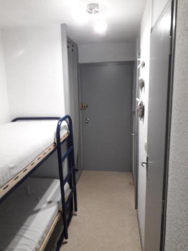 une chambre avec un lit et une porte donnant sur un couloir dans l'établissement Studio à vars, à Vars