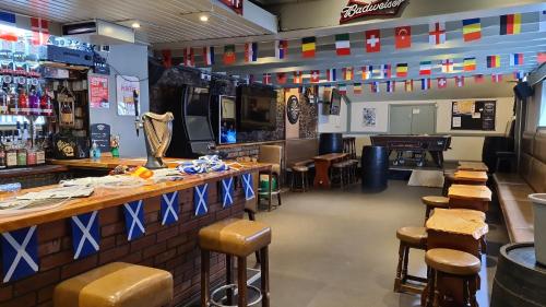 a restaurant with tables and stools and a bar at The Stag Hotel in Banchory
