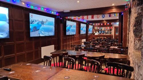 a dining room with tables and chairs and televisions at The Stag Hotel in Banchory