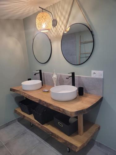 une salle de bain avec deux lavabos et deux miroirs dans l'établissement Gîte Chez Paulette, à Cerbois