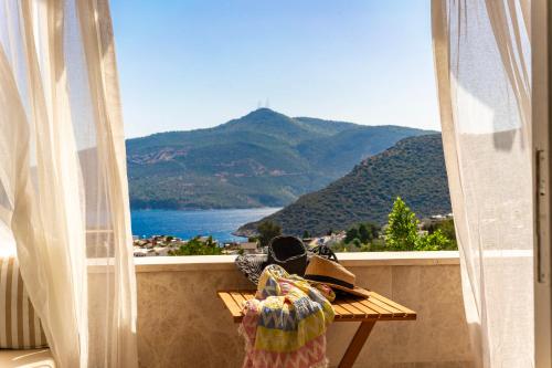 a balcony with a table and a view of a mountain at Elixir Hotel in Kalkan