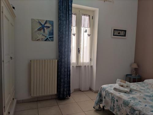 a bedroom with a bed and a window with curtains at Mediterraneo Camere in Otranto