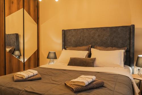 a bedroom with a large bed with two towels on it at - All-Around Skopje Apartments - Premium Hospitality - in Skopje