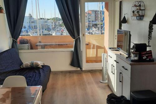 un salon avec un canapé et une grande fenêtre dans l'établissement bord de la mer vue sur le port à leucate, port leucate, à Leucate