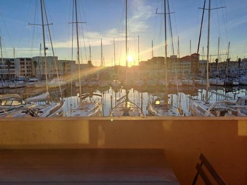 un groupe de bateaux amarrés dans une marina au coucher du soleil dans l'établissement bord de la mer vue sur le port à leucate, port leucate, à Leucate