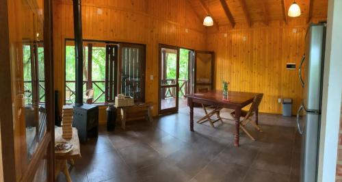 a living room with a table and some windows at Cabañas en Reserva Privada Bahía Santa Ana in Santa Ana