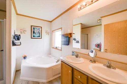 McEwenWarm and Inviting Family Home - 2 Mi to Golf Course!的配有两个水槽、一个浴缸和一面镜子的浴室