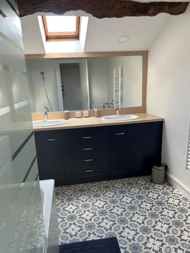 une salle de bain avec deux lavabos et un grand miroir dans l'établissement Les Murgers Au coeur des Vignes, à Prissé