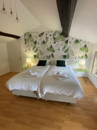 - une chambre avec un lit blanc et 2 serviettes dans l'établissement Les Murgers Au coeur des Vignes, à Prissé