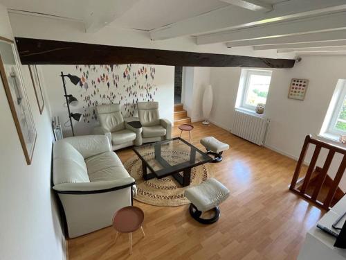 a living room with a white couch and a glass table at Les Murgers Au coeur des Vignes in Prissé