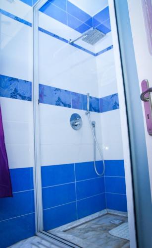 a bathroom with a shower with blue tiles at Penthouse de luxe 5 min de la plage in Al Matlīn