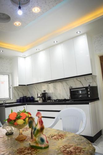 a kitchen with a table with a bowl of fruit on it at Penthouse de luxe 5 min de la plage in Al Matlīn