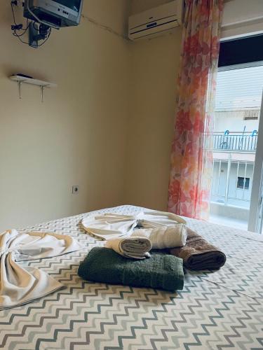 a room with a bed with a towel and a window at Villa Maria Petru in Ierissos