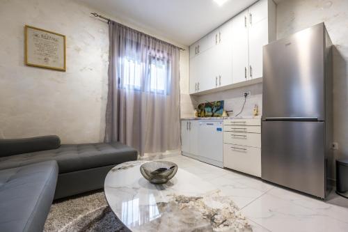 a living room with a stainless steel refrigerator and a table at Apartment Sofija in Herceg-Novi