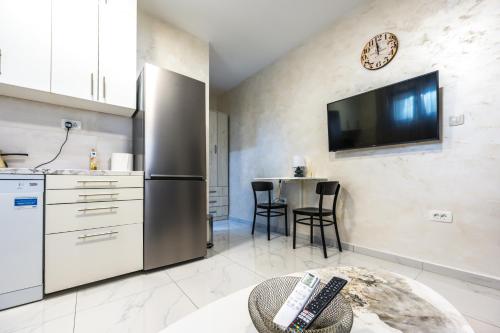 a kitchen with a stainless steel refrigerator and a table at Apartment Sofija in Herceg-Novi