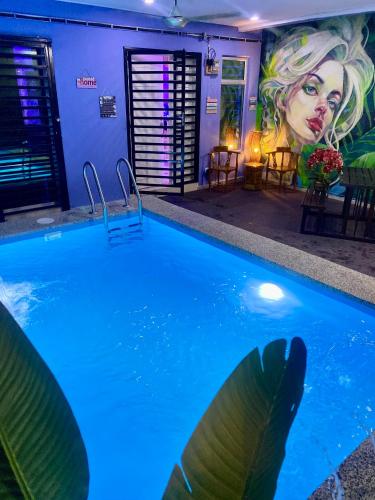 a swimming pool with a mural of a woman at Ilham Restu Homestay Private Pool MSLIM ONLY in Port Dickson