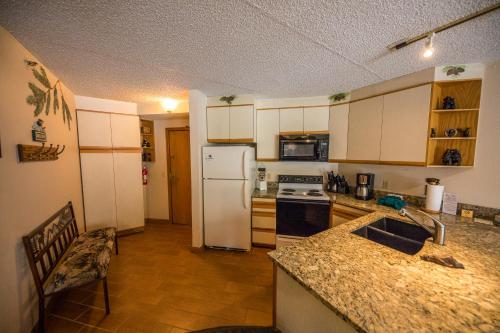 cocina con nevera blanca y encimera en Iron Horse Building C Unit 1023, en Winter Park